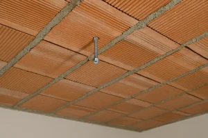 Fixation plafond en brique creuse avec tige filetée ancrée dans une zone porteuse