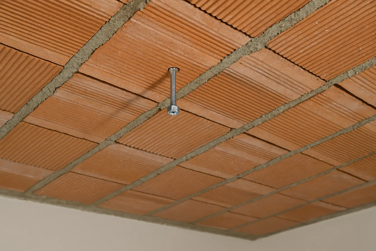 Fixation plafond en brique creuse avec tige filetée ancrée dans une zone porteuse