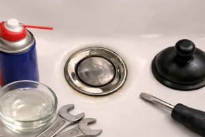 Bonde de lavabo clic-clac bloquée avec traces de calcaire, vue de dessus dans un lavabo blanc
