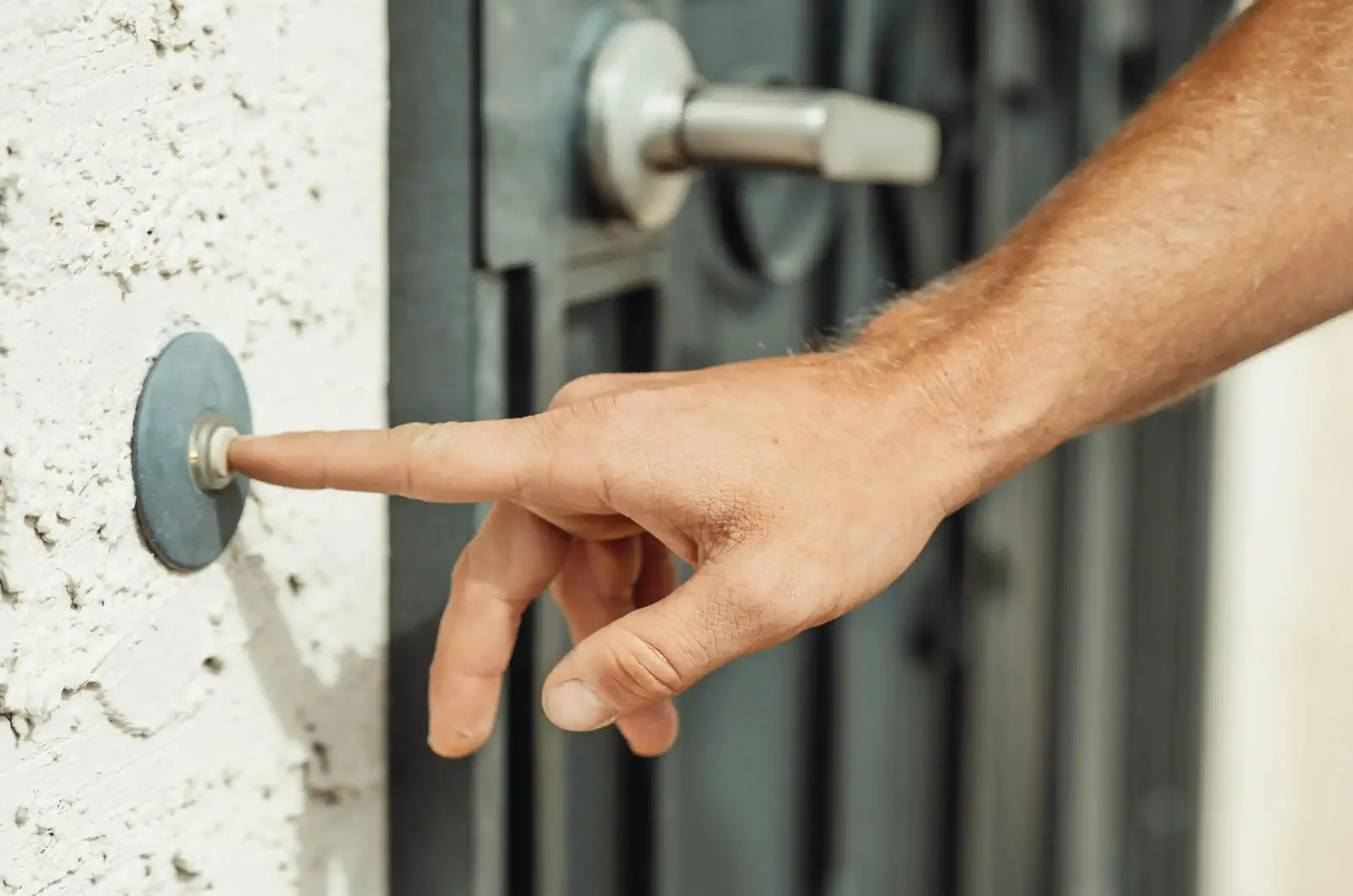 Appuyer sur une sonnette de porte trop discrète à l’entrée d’une maison