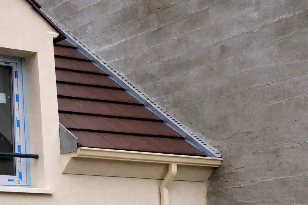 Toiture adossée à un mur avec solin en zinc pour l’étanchéité en mitoyenneté