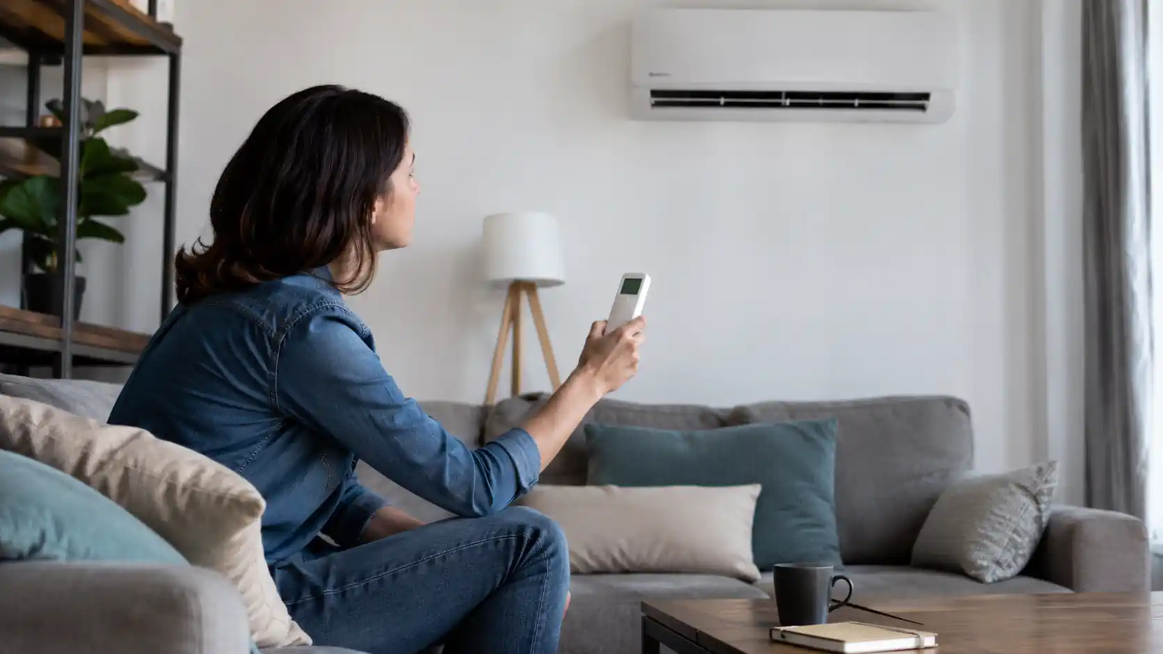 Personne vérifiant un climatiseur mural qui semble avoir un problème de fonctionnement