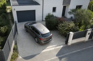 Voiture manœuvrant sur une aire de retournement devant une maison individuelle