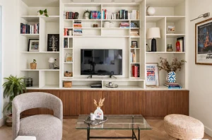 Salon lumineux d’un appartement parisien rénové avec bibliothèque sur mesure